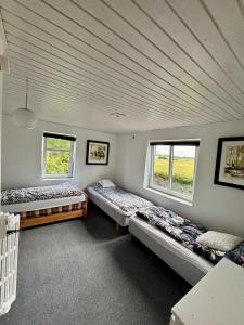 two beds in a room with two windows at Big House Near Beach & Lake in Haderslev