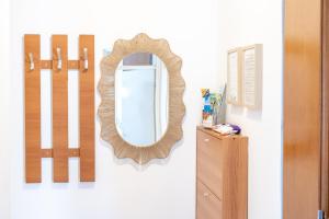 a mirror hanging on a wall next to a dresser at Apartman Zvezda in Igalo +15 photos