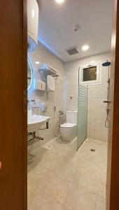 a bathroom with a toilet and a sink and a shower at Taj Aleiman Hotel  in Medina