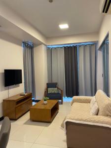 Una sala de estar con un sofá y un televisor en Studio with balcony in 8 Newtown Blvd, en Punta Engaño