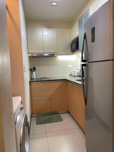 una pequeña cocina con nevera y armarios en Studio with balcony in 8 Newtown Blvd, en Punta Engaño