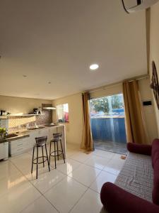 a kitchen with a counter and stools in a room at Casinhas da Vila in Itacaré +43 photos
