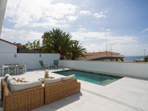 a patio with two wicker chairs and a swimming pool at Las Burras Ocean Front Views in San Agustin