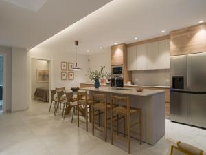 an open kitchen with a island and bar stools at Las Burras Ocean Front Views in San Bartolomé