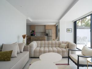 a living room with a white couch and tables at Las Burras Ocean Front Views in San Bartolomé +66 photos
