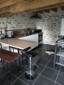 a kitchen with a wooden table and a sink at Les Gîtes des Chaumes de Villeneuve - Le Loft 