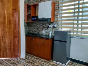 a kitchen with a stainless steel refrigerator and wooden cabinets at Golden Homes in Dodoma