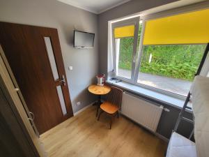 a small room with a table and a window at Pokoje Gościnne Grzybowo in Grzybowo