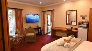 a hotel room with a bed and a desk and a kitchen at Lamor Guest House in Middelburg