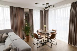 a living room with a couch and a table with chairs at Panorama Prestige by Elite Apartments in Starogard Gdański