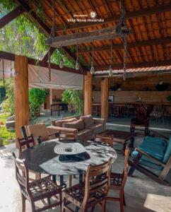 a patio with a table and chairs and a couch at Villa Nova Holanda in Guaramiranga