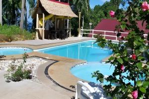 a pool at a resort with a building at D & A Seaside Cottages in Catarman