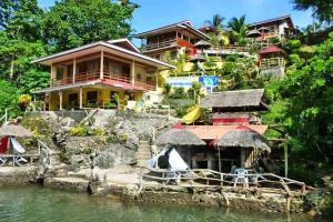 a house on a hill next to a body of water at D & A Seaside Cottages in Catarman