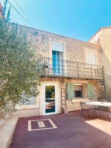 a building with a balcony and a table and bench at Oustalou Bel Air in Puisserguier +1 photo