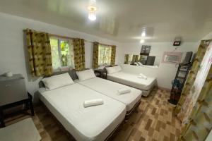 a bedroom with two beds and a living room at D & A Seaside Cottages in Catarman +57 photos