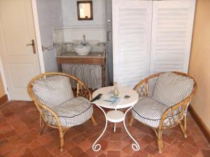 two chairs and a table in a room with a sink at La Maison d'hôtes du Bec d'Allier in Marzy