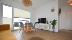 a living room with a table and chairs and a television at VacationClub - Słoneczne Osiedle Apartament 17 in Ustronie Morskie