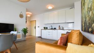 a living room with a couch and a kitchen at VacationClub - Słoneczne Osiedle Apartament 17 in Ustronie Morskie