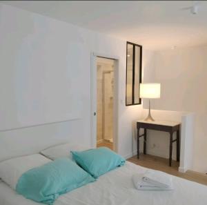 ein Schlafzimmer mit einem Bett mit einer Lampe und einem Tisch in der Unterkunft AU PIED DE LA MER AU COEUR DE LA STATION bel appartement contemporain in Bénodet