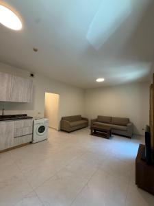 a living room with two couches and a stove at Laforge Residence in Al Bāţiyah