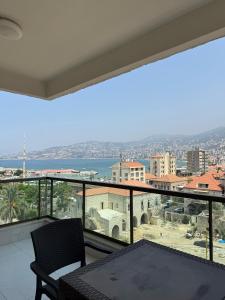 a balcony with a view of a city and the ocean at Laforge Residence in Al Bāţiyah