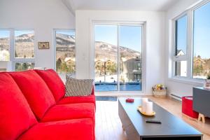 a red couch in a living room with windows at Mountain View - World Cup in Beaupré