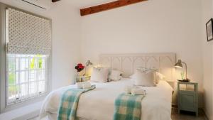 a bedroom with a large white bed with two pillows at River Bend Cottages in Graaff-Reinet