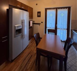 a kitchen with a wooden table and a refrigerator at Claudio&Meri's House in Isola del Gran Sasso dʼItalia