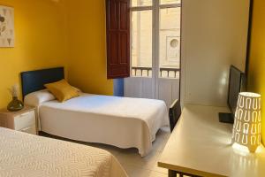 a small room with two beds and a window at Casa Antares in Granada