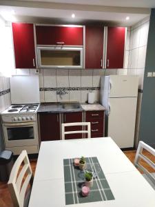a kitchen with a white table and a white refrigerator at Apartman Zdravković in Leskovac +23 photos