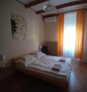 a bedroom with a bed and a window at Pitypang Vendégház Villány in Villány
