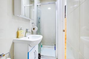 a white bathroom with a sink and a shower at Abbey Hotel in London