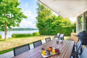 a wooden table with a plate of food on a patio at Resort Boschmolenplas in Heel