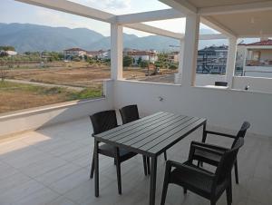 a wooden table and chairs on a balcony with a view at GN summer guest house P in Leptokarya