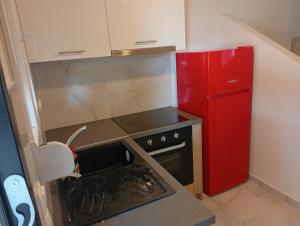 a small kitchen with a red refrigerator and an oven at GN summer guest house P in Leptokarya