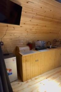 Una cocina con paredes de madera y una encimera con refrigerador. en Cottage Khevi 64, en Khulo 1 foto más