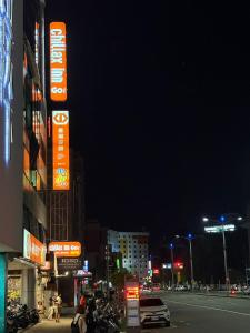 a city street at night with neon signs at Chillax Inn 知樂愛河館 in Kaohsiung