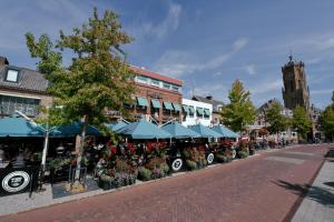 a street with a group of umbrellas and flowers at Het Wapen van Elst in Elst