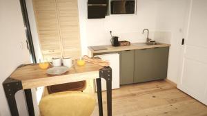 a kitchen with a wooden table with two glasses of orange juice at La Maison de l'horloge in Bagnères-de-Bigorre