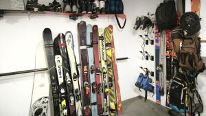 a bunch of skis are lined up against a wall at La Maison de l'horloge in Bagnères-de-Bigorre