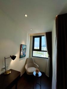 une chambre d'hôtel avec une chaise et une fenêtre dans l'établissement The Sapphire City Park, à Hạ Long