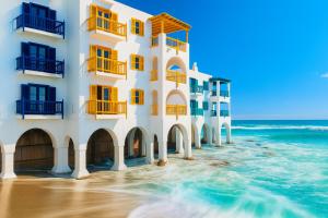 a building on the beach next to the ocean at Kaliva 136 Club Mykonos, Langebaan in Langebaan