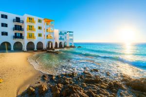 a building on the beach next to the ocean at Kaliva 136 Club Mykonos, Langebaan in Langebaan