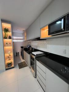 a kitchen with a stove and a microwave at Apartamento top bem localizado in Vitória da Conquista +14 photos
