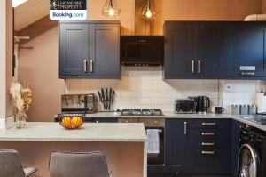 a kitchen with black cabinets and a counter top at Beautiful 3BDR House By Homebird Property Management Short Lets & Serviced Accommodation Leeds With Free Parking & Free WiFi in Leeds