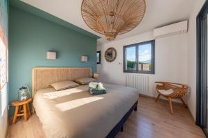 une chambre avec un grand lit et une chaise dans l'établissement NOUVEAUTÉ ! Magnifique villa de standing avec piscine, entre mer et montagnes, à 3 minutes des plus belles plages de la rive sud, à Porticcio 26 autres photos