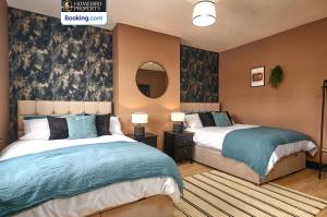 a bedroom with two beds and a mirror at Beautiful 3BDR House By Homebird Property Management Short Lets & Serviced Accommodation Leeds With Free Parking & Free WiFi in Leeds