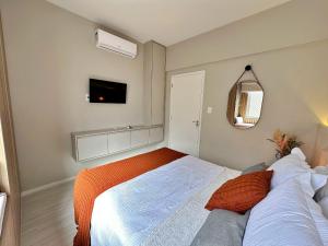 ein Schlafzimmer mit einem Bett und einem Fernseher an der Wand in der Unterkunft Home 403 - Studio sofisticado no centro de Floripa in Florianópolis