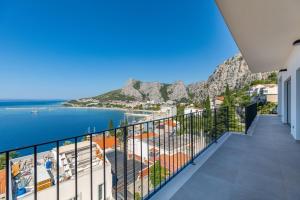 a balcony with a view of the water and mountains at Penthouse Andro, Omis in Omiš