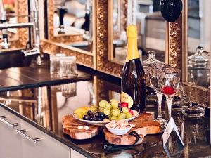 a bottle of wine and a plate of fruit on a counter at Vintage Cozy Suite in Vodno +6 photos